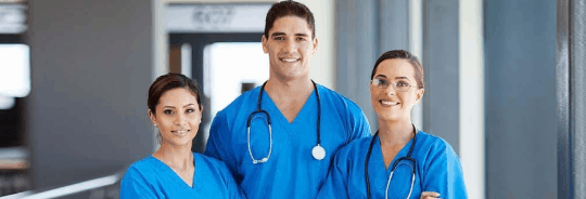 3 Asistenți Medicali, 2 fete și un băiat care sunt îmbrăcați în albastru, doi dintre ei având câte un stetoscop la gât
