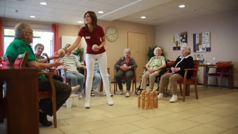 Asistentă medicală care lucrează la o Reședință de seniori MediClub Germania care face diverse jocuri cu bătrânii din centru